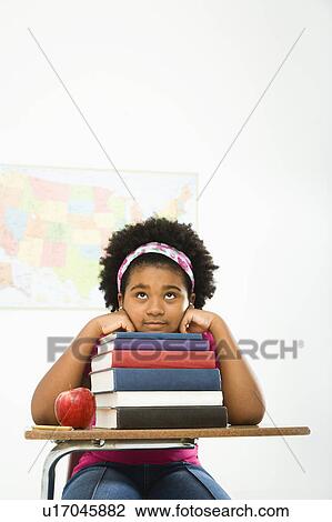 Stock Image - Girl sitting in school desk . Fotosearch