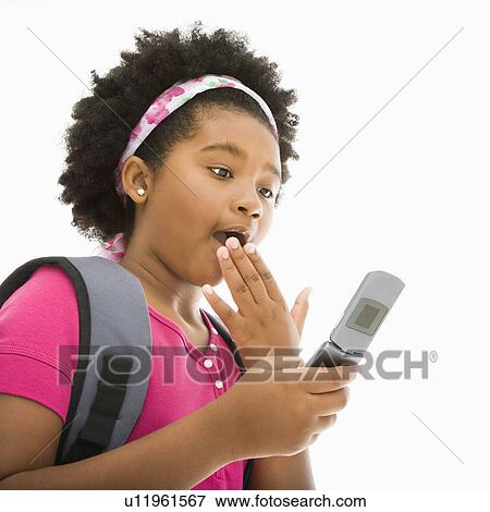 Stock Photo - Girl with backpack looking at cell phone with surprised expression. Fotosearch