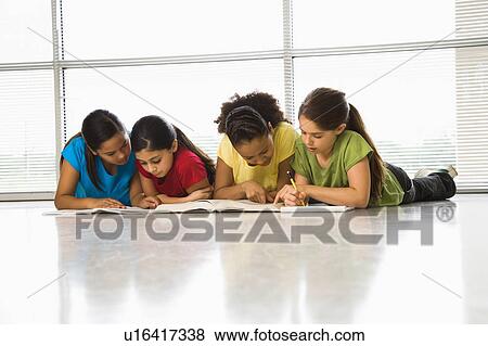 Girls lying on floor with schoolwork View Large Photo Image Stock Photo - Girls lying on floor with schoolwork. Fotosearch