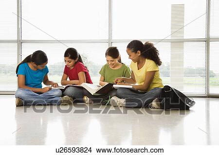 Girls sitting together on floor with schoolwork View Large Photo Image Picture - Girls sitting together on floor with schoolwork. Fotosearch