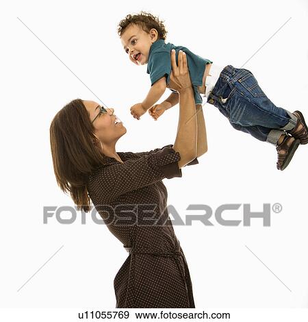Side view of mid adult African American mom lifting happy toddler son into air above head. View Large Photo Image Stock Photo - Side view of mid adult African American mom lifting happy toddler son into air above head.. Fotosearch