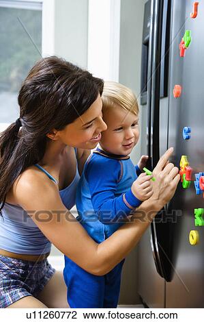 Toddler boy and mother playing with magnets on refrigerator View Large Photo Image Stock Image - Toddler boy and mother playing with magnets on refrigerator. Fotosearch