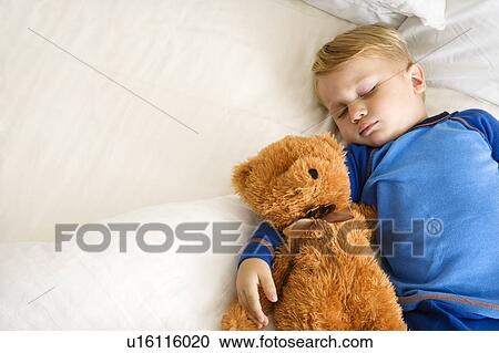 Toddler boy sleeping in bed with teddy bear View Large Photo Image Stock Image - Toddler boy sleeping in bed with teddy bear. Fotosearch