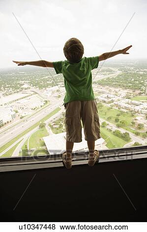 Stock Photo - Young Caucasian boy standing on observation deck at Tower of the Americas in San Antonio, Texas.. Fotosearch