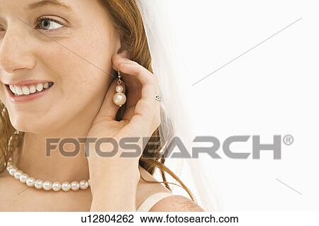 Bride adjusting her earring View Large Photo Image Stock Image - Bride adjusting her earring. Fotosearch