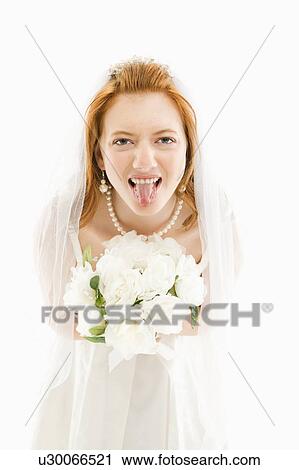 Stock Image - Bride holding bouquet and sticking her tongue out. Fotosearch