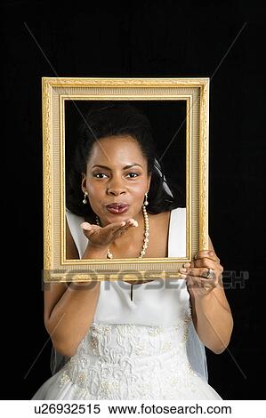 Bride holding frame around her face and blowing a kiss View Large Photo Image Stock Photography - Bride holding frame around her face and blowing a kiss. Fotosearch