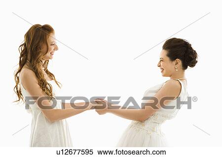 Stock Photography - Bride pulling bride towards her. Fotosearch