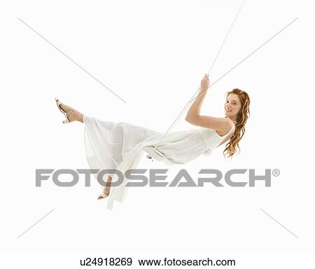 Stock Photo - Bride swinging in swing set and looking at viewer. Fotosearch