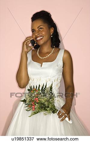 Bride talking on cellphone on pink background View Large Photo Image Stock Photo - Bride talking on cellphone on pink background. Fotosearch