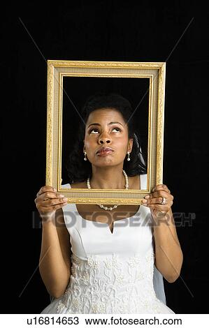 Mid-adult African-American bride holding frame around her face. View Large Photo Image Stock Image - Mid-adult African-American bride holding frame around her face.. Fotosearch