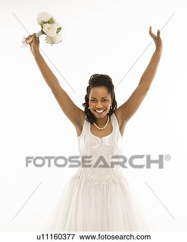 Stock Photo - Portrait of a bride holding bouquet with arms raised. Fotosearch