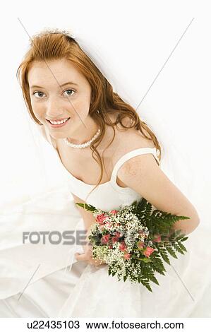 Stock Image - Portrait of a Caucasian bride holding bouquet.. Fotosearch