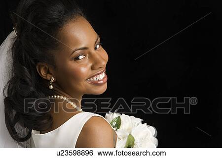Stock Photograph - Portrait of a mid-adult bride on black background. Fotosearch