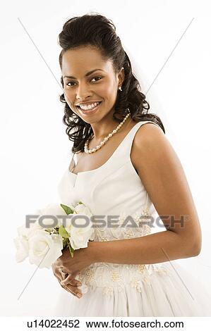 Stock Image - Portrait of a mid-adult African-American bride holding bouquet.. Fotosearch