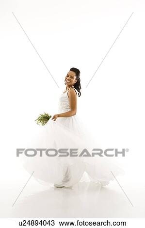 Stock Image - Portrait of a mid-adult African-American bride holding bouquet.. Fotosearch