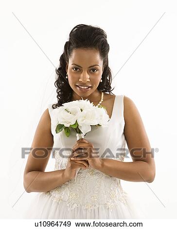 Stock Photo - Portrait of a mid-adult African-American bride holding bouquet.. Fotosearch