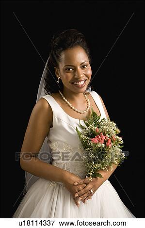 Stock Photo - Portrait of a mid-adult African-American bride on black background.. Fotosearch
