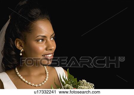 Stock Image - Portrait of bride holding bouquet.. Fotosearch
