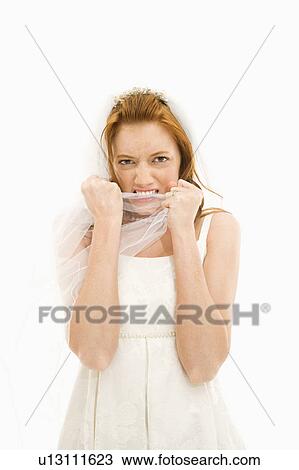 Stock Image - Portrait of Caucasian bride biting her veil.. Fotosearch