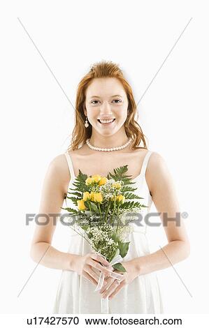 Stock Image - Portrait of Caucasian bride holding bouquet.. Fotosearch