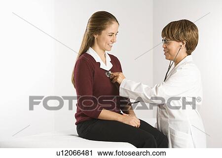 African American middle-aged female doctor examining Caucasian mid-adult female patient with stethoscope. View Large Photo Image Stock Image - African American middle-aged female doctor examining Caucasian mid-adult female patient with stethoscope.. Fotosearch