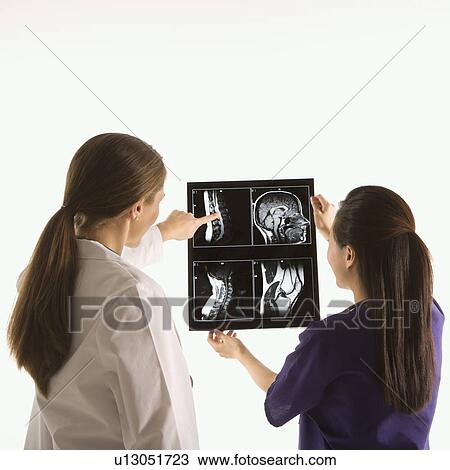 Caucasian and Asian Chinese mid-adult female doctors analyzing x-ray. View Large Photo Image Stock Image - Caucasian and Asian Chinese mid-adult female doctors analyzing x-ray. . Fotosearch