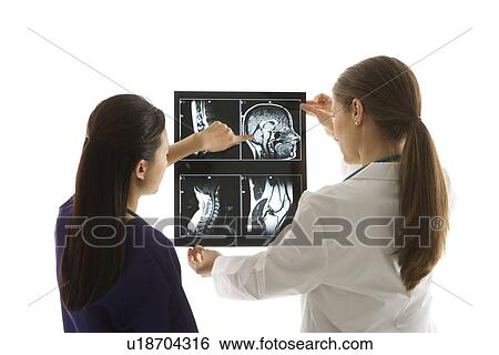 Caucasian and Asian Chinese mid-adult female doctors analyzing x-ray. View Large Photo Image Stock Photograph - Caucasian and Asian Chinese mid-adult female doctors analyzing x-ray. . Fotosearch