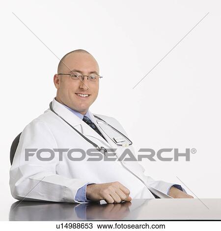 Caucasian mid adult male physician sitting at desk smiling. View Large Photo Image Stock Image - Caucasian mid adult male physician sitting at desk smiling.. Fotosearch