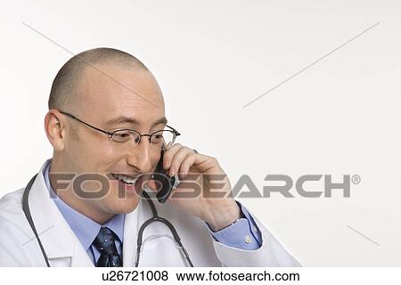 Stock Photo - Caucasian mid adult male physician talking on cellphone.. Fotosearch