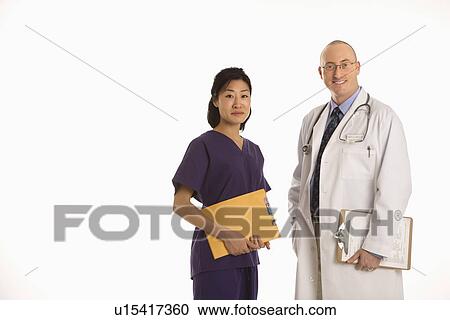 Caucasian mid adult male physician with Asian woman doctor. View Large Photo Image Stock Image - Caucasian mid adult male physician with Asian woman doctor.. Fotosearch