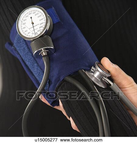 Stock Photo - Close up of doctor testing blood pressure of patient.. Fotosearch