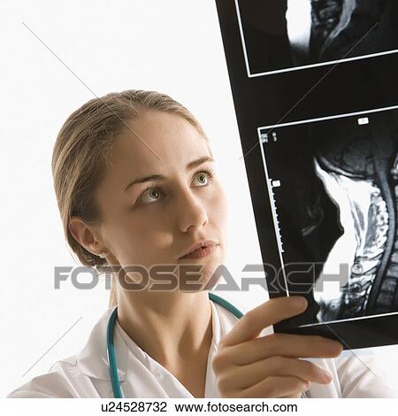 Stock Image - Female doctor analyzing x-ray . Fotosearch