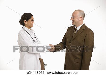 Indian mid adult woman doctor shaking hands with man in business suit. View Large Photo Image Stock Image - Indian mid adult woman doctor shaking hands with man in business suit.. Fotosearch