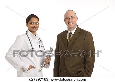 Stock Image - Indian mid adult woman doctor with man in business suit.. Fotosearch