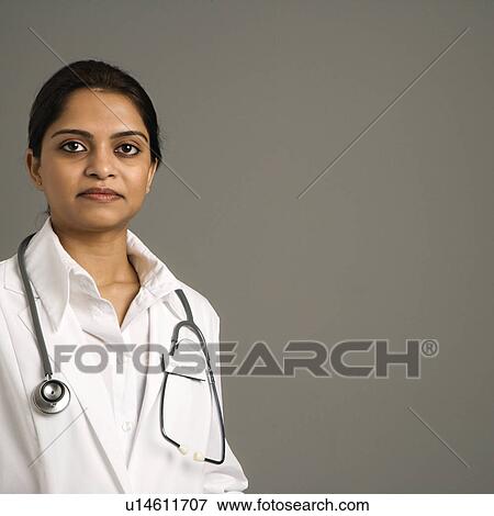 Stock Photo - Indian woman doctor head and shoulder portrait on gray background.. Fotosearch