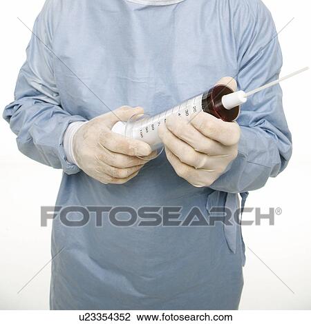 Mid-adult Caucasian male wearing scrubs and holding an oversized syringe. View Large Photo Image Stock Image - Mid-adult Caucasian male wearing scrubs and holding an oversized syringe.. Fotosearch