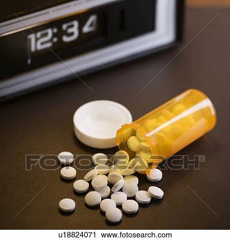 Open medicine bottle with pills spilling out onto table with clock in background. View Large Photo Image Stock Image - Open medicine bottle with pills spilling out onto table with clock in background.. Fotosearch