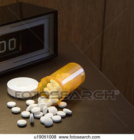 Open medicine bottle with pills spilling out onto table with clock in background. View Large Photo Image Stock Photo - Open medicine bottle with pills spilling out onto table with clock in background.. Fotosearch