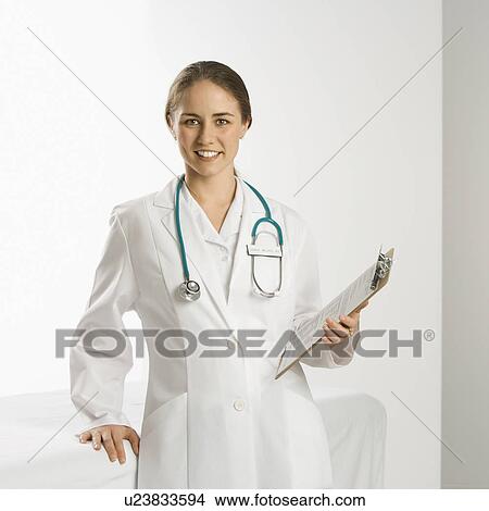 Picture - Portrait of Caucasian mid-adult female doctor smiling and looking at viewer.. Fotosearch