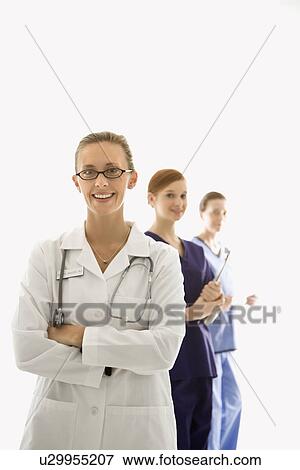 Portrait of smiling Caucasian medical healthcare workers in uniforms standing against white background. View Large Photo Image Stock Photo - Portrait of smiling Caucasian medical healthcare workers in uniforms standing against white background.. Fotosearch