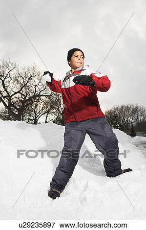Boy standing in snow throwing snowball. View Large Photo Image Stock Photo - Boy standing in snow throwing snowball.. Fotosearch