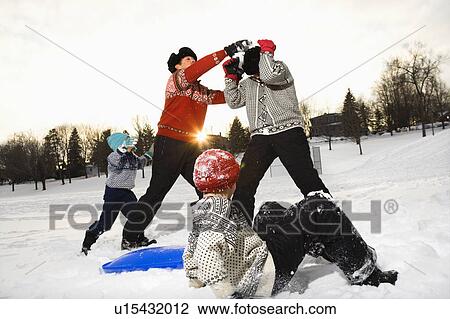 Caucasian family of four having fun playing in snow. View Large Photo Image Stock Image - Caucasian family of four having fun playing in snow.. Fotosearch