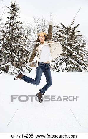 Caucasian young adult female leaping into the air in snowly climate wearing straw cowboy hat. View Large Photo Image Stock Photo - Caucasian young adult female leaping into the air in snowly climate wearing straw cowboy hat.. Fotosearch