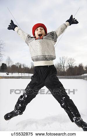Excited Caucasian boy wearing sweater and red winter cap jumping in air with arms and legs outstretched. View Large Photo Image Stock Photography - Excited Caucasian boy wearing sweater and red winter cap jumping in air with arms and legs outstretched.. Fotosearch