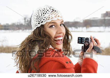 Female in winter clothing holding video camera View Large Photo Image Stock Image - Female in winter clothing holding video camera. Fotosearch