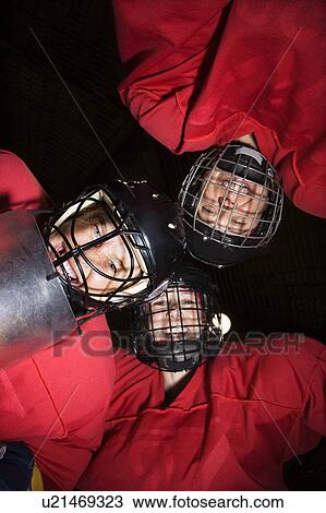 Low angle of female hockey players in huddle smiling View Large Photo Image Stock Image - Low angle of female hockey players in huddle smiling. Fotosearch