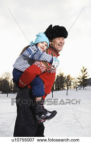 Man holding little girl piggyback style smiling and looking at viewer View Large Photo Image Stock Photo - Man holding little girl piggyback style smiling and looking at viewer. Fotosearch