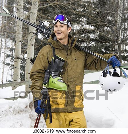 Man in walking carrying ski equipment View Large Photo Image Stock Photo - Man in walking carrying ski equipment. Fotosearch
