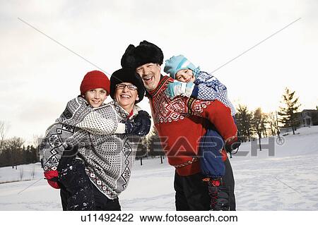 Stock Image - Parents carrying son and daughter. Fotosearch